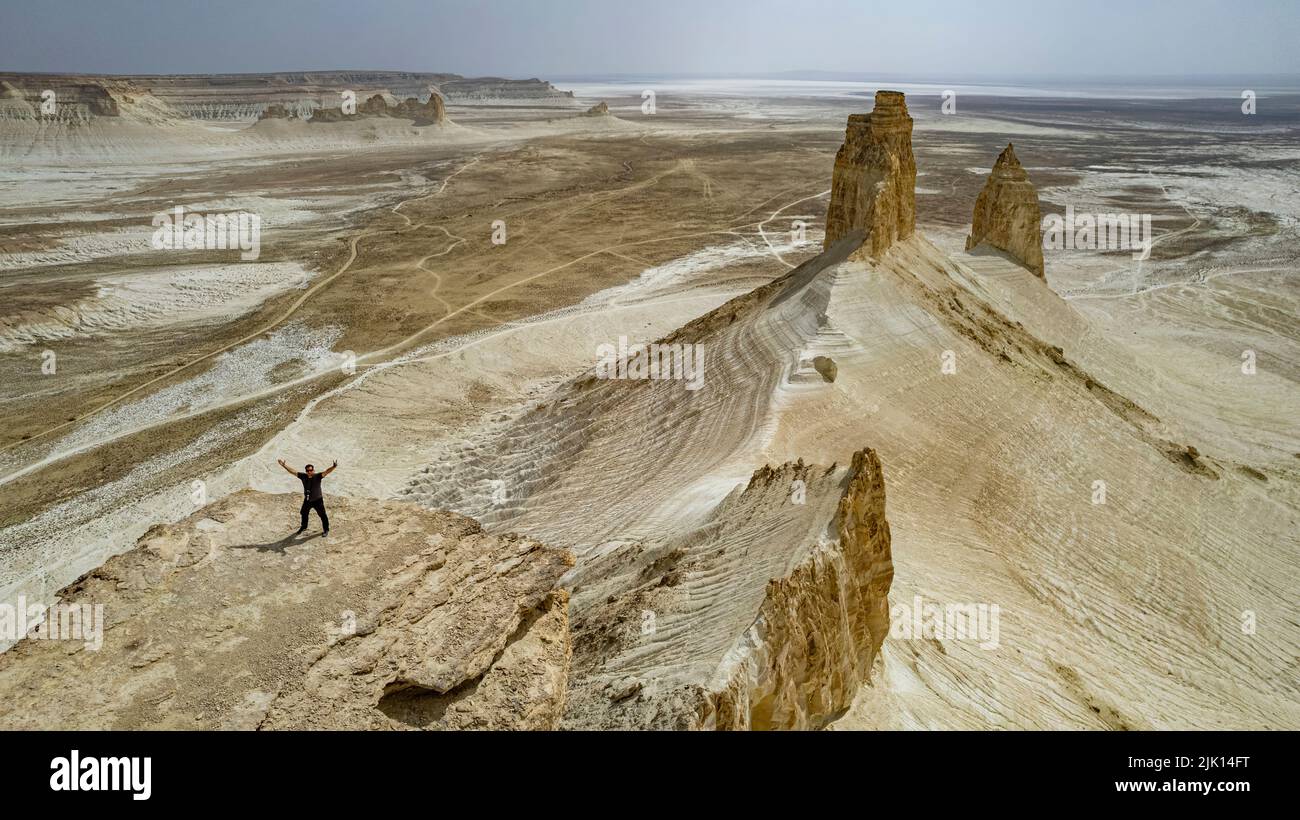 Luftaufnahme eines Mannes, der auf einer Klippe steht, Bozzhira Canyon, Ustyurt-Hochebene, Mangystau, Kasachstan, Zentralasien, Asien Stockfoto