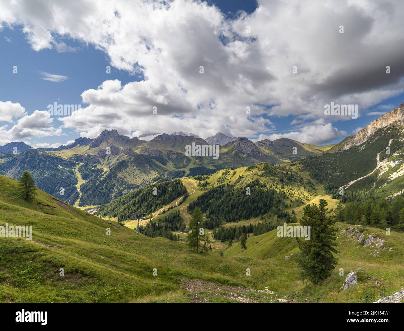 Almen an einem sonnigen Tag mit einem weißen bewölkten Himmel und Licht beleuchtet den Berg unten, Dolomiten, Italien, Europa Stockfoto