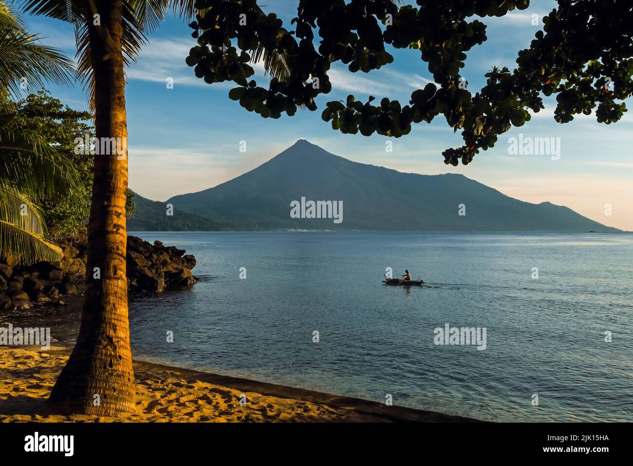Kalea Beach Sonnenuntergang mit Palmen, Kanu und Karangetang Vulkan, Kalea, Siau Island, Sangihe Archipel, Nord Sulawesi, Indonesien Stockfoto