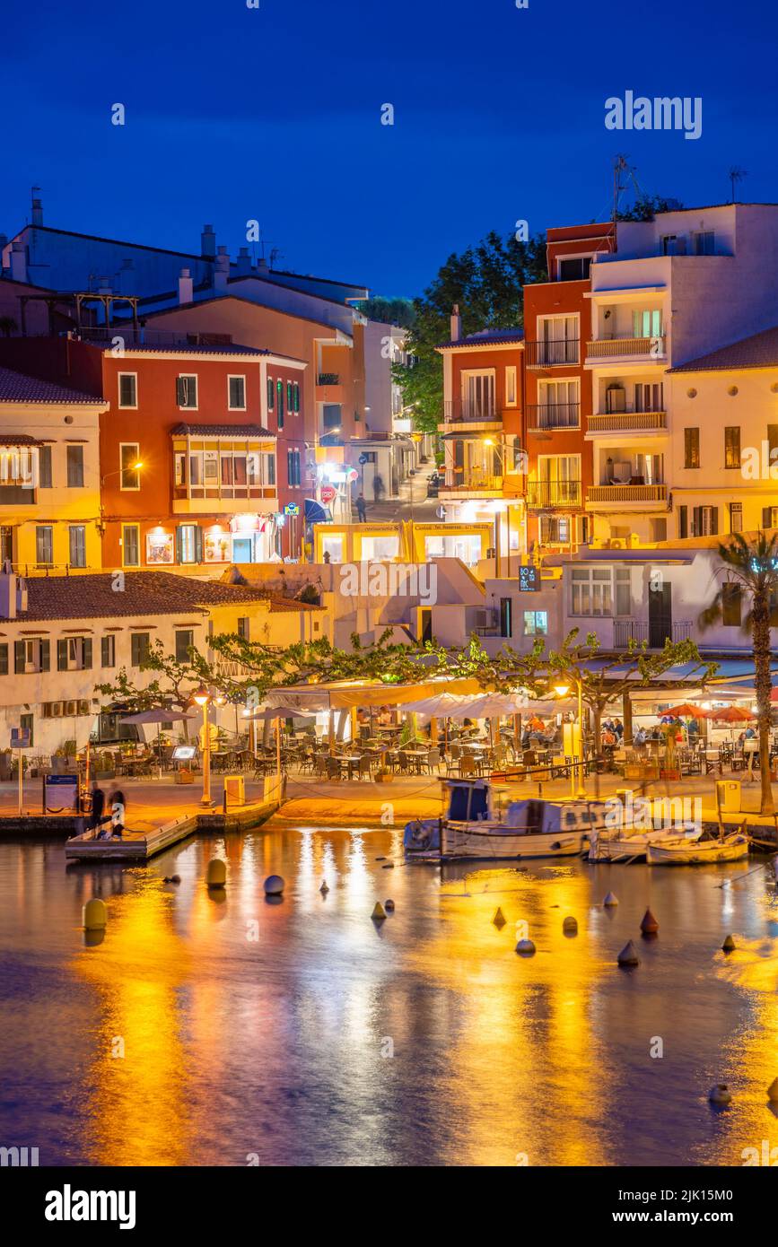 Blick auf Cafés, Restaurants und Boote im Hafen in der Abenddämmerung, Cales Fonts, Es Castell, Menorca, Balearen, Spanien, Mittelmeer, Europa Stockfoto