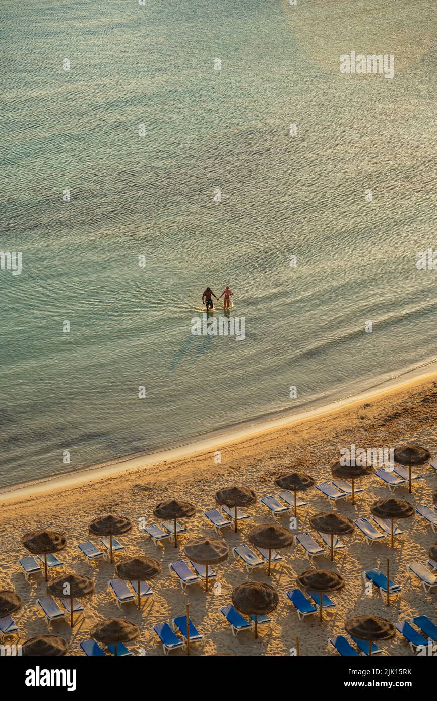 Blick auf Paare im Meer und Sonnenschirme auf Platja de Cala Galdana in Cala Galdana, Cala Galdana, Menorca, Balearen, Spanien, Mittelmeer, Europa Stockfoto