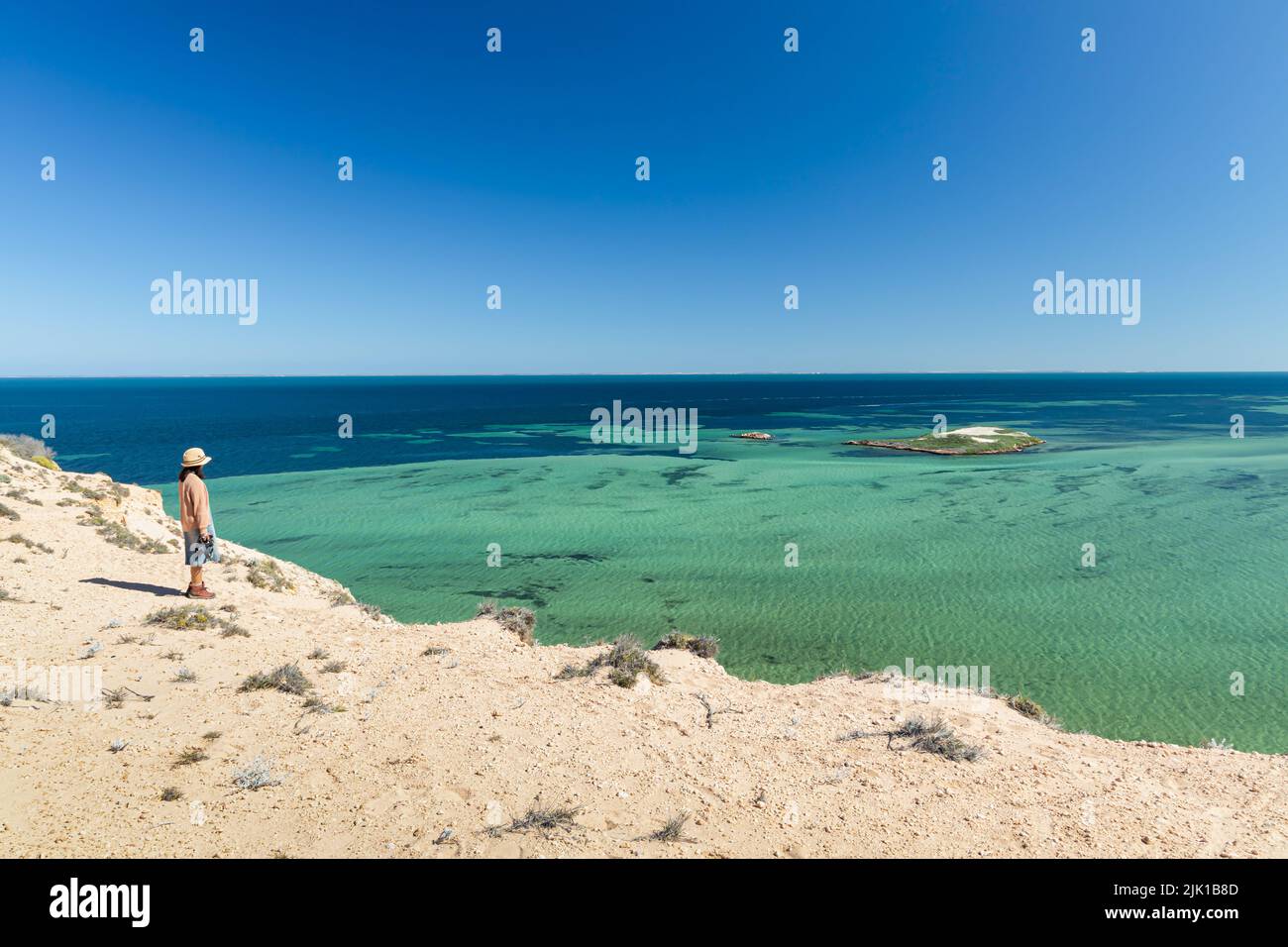 Eine Dame schaut auf das wunderschöne Wasser von Eagle Bluff, Denham, Shark Bay, Westaustralien Stockfoto
