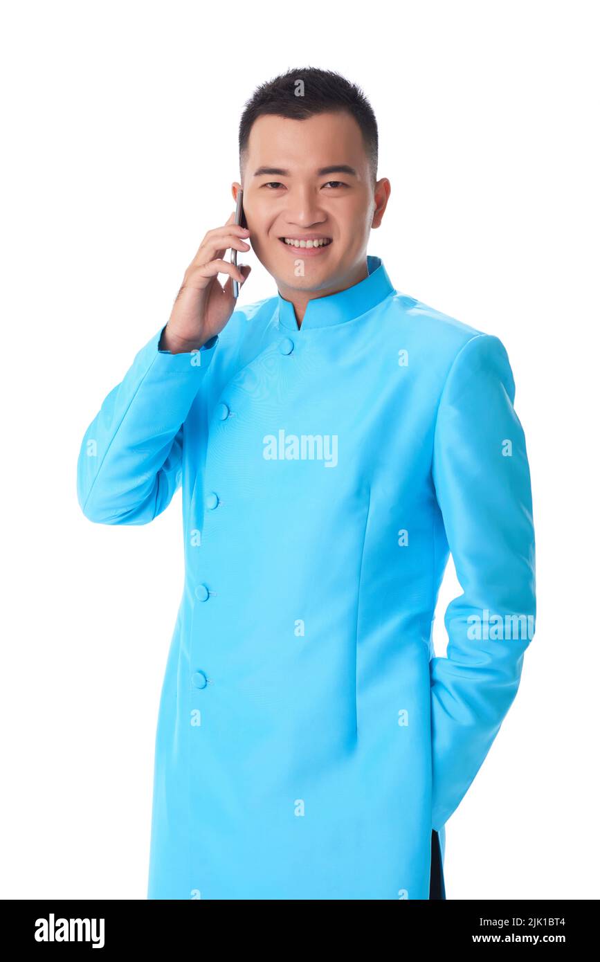 Studioaufnahme des jungen Vietnams in Nationalkostüm, der am Telefon anrief Stockfoto