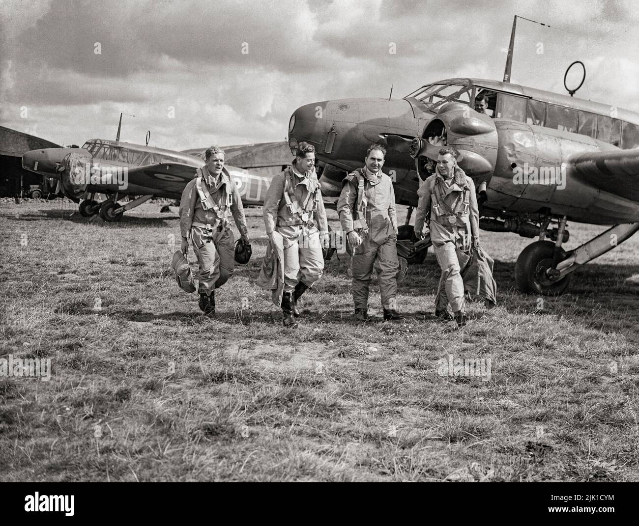 Piloten der RAF-Staffel Nr. 320 oder 321 (holländisch) laufen zu ihrem Avro Anson Mark ist in Carew Cheriton, Pembrokeshire. Beide Geschwader wurden am 1. Juni 1940 aus Mitgliedern des Royal Netherlands Naval Air Service gebildet, die nach der Invasion Hollands nach Großbritannien geflohen waren. Es war ein britisches zweimotoriges, mehrreihiges Flugzeug, hauptsächlich Aufklärungsflugzeug, das vor, während und nach dem Zweiten Weltkrieg bei der Royal Air Force (RAF), Fleet Air Arm (FAA), der Royal Canadian Air Force (RCAF) und anderen Luftstreitkräften diente. Stockfoto