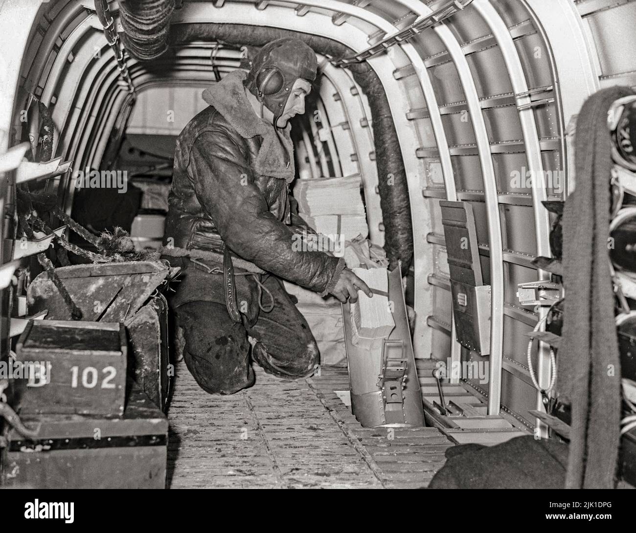 Einer der Luftbesatzungen eines Armstrong Whitworth Whitley Mark V einer Abteilung der RAF-Staffel der 102. Staffel in Villeneuve/Vertus, Frankreich, demonstrierte, wie Propagandaflugzeuge durch die Fackelrutsche auf Flugblatt-Fallbeispielen geworfen wurden. Der Armstrong Whitworth Whitley war einer von drei britischen zweimotorigen mittleren Bombertypen an der Front, die bei Ausbruch des Zweiten Weltkriegs bei der Royal Air Force im Einsatz waren und an dem ersten Bombenangriff der RAF auf deutsches Gebiet teilnahmen. Sie blieb bis zur Einführung von viermotorigen „Schweren“ ein integraler Bestandteil der frühen britischen Bomberoffensive. Stockfoto