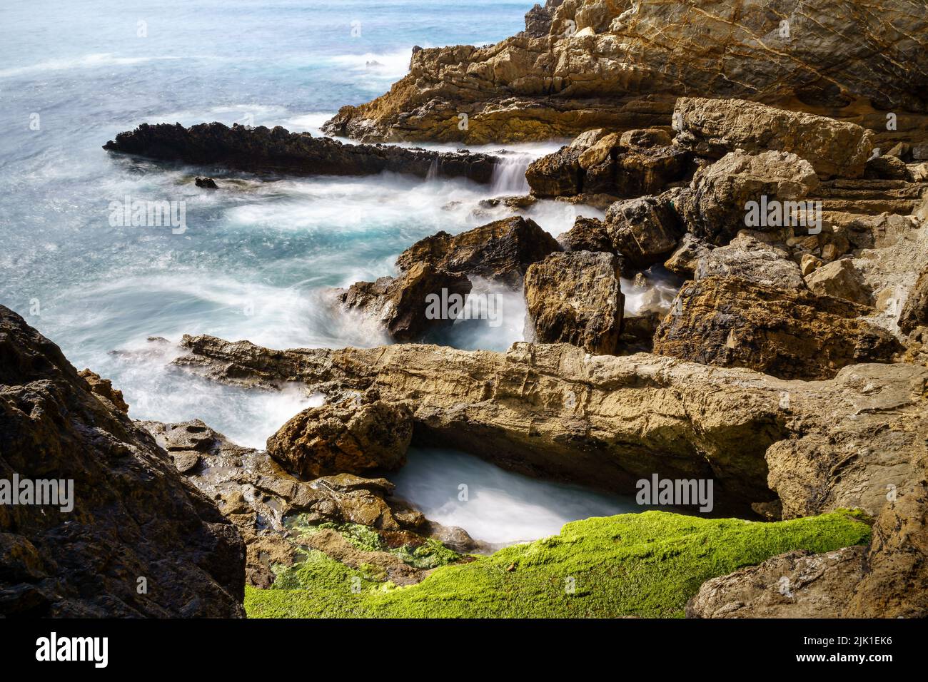 Wellen, die in Langzeitaufnahmen gegen Felsen krachen. Santander Spanien. Stockfoto