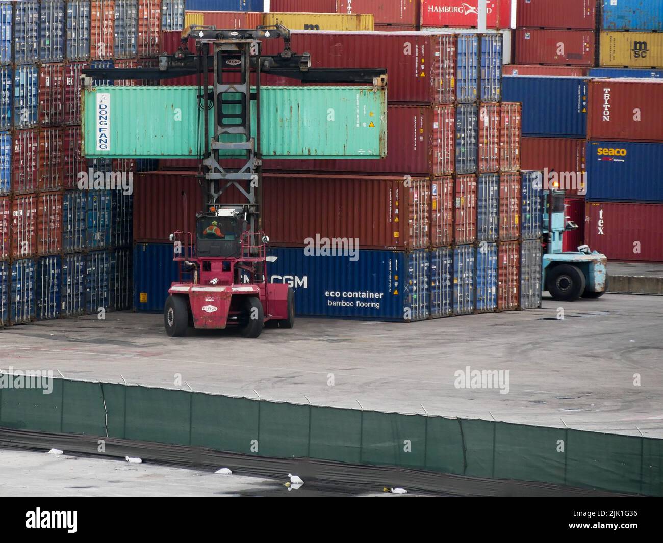 Forkilft arbeitet mit einem Stapel von Containern in verschiedenen Farben im Hafen von Miami Stockfoto