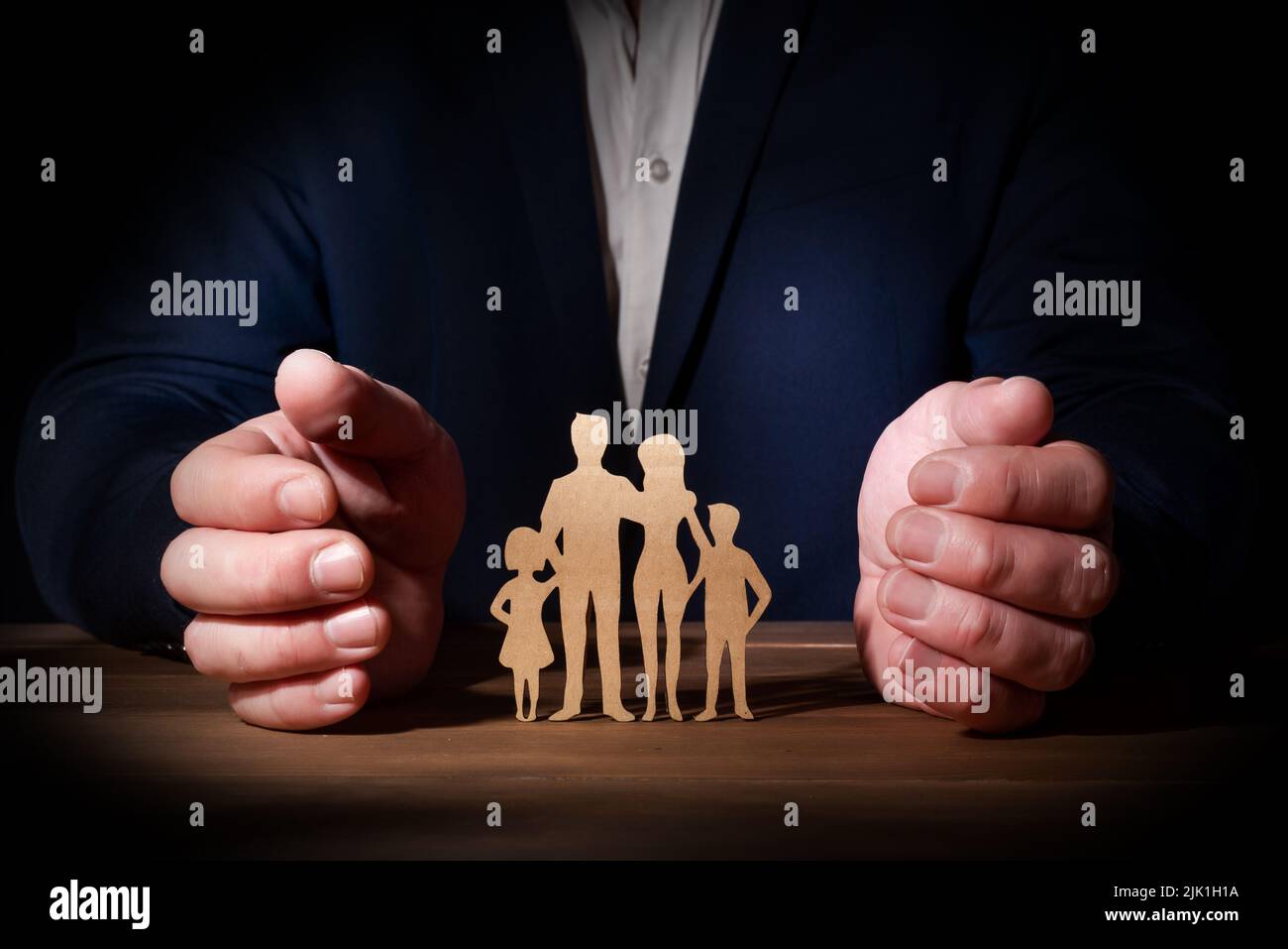 Die Hände eines professionellen Schutz einer Familie. Versicherung für Gesundheit, Leben und Seelenfrieden bei unvorhergesehenen Ereignissen und Problemen Stockfoto