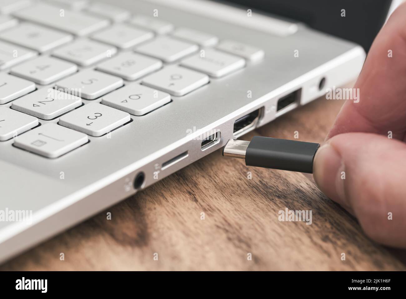 Stecken Sie den USB-Stecker des Typs C in den USB-Anschluss des Laptops Stockfoto