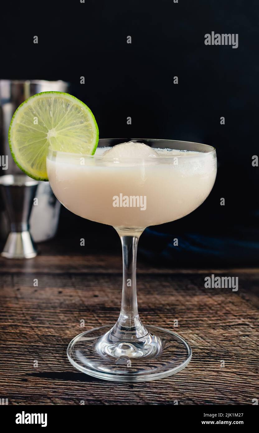 White Chocolate Gimlet Gin Cocktail mit Eiskugel: Cocktail aus Gin, Limette Cordial und weißem Schokoladenlikör in einem Coupé-Glas Stockfoto