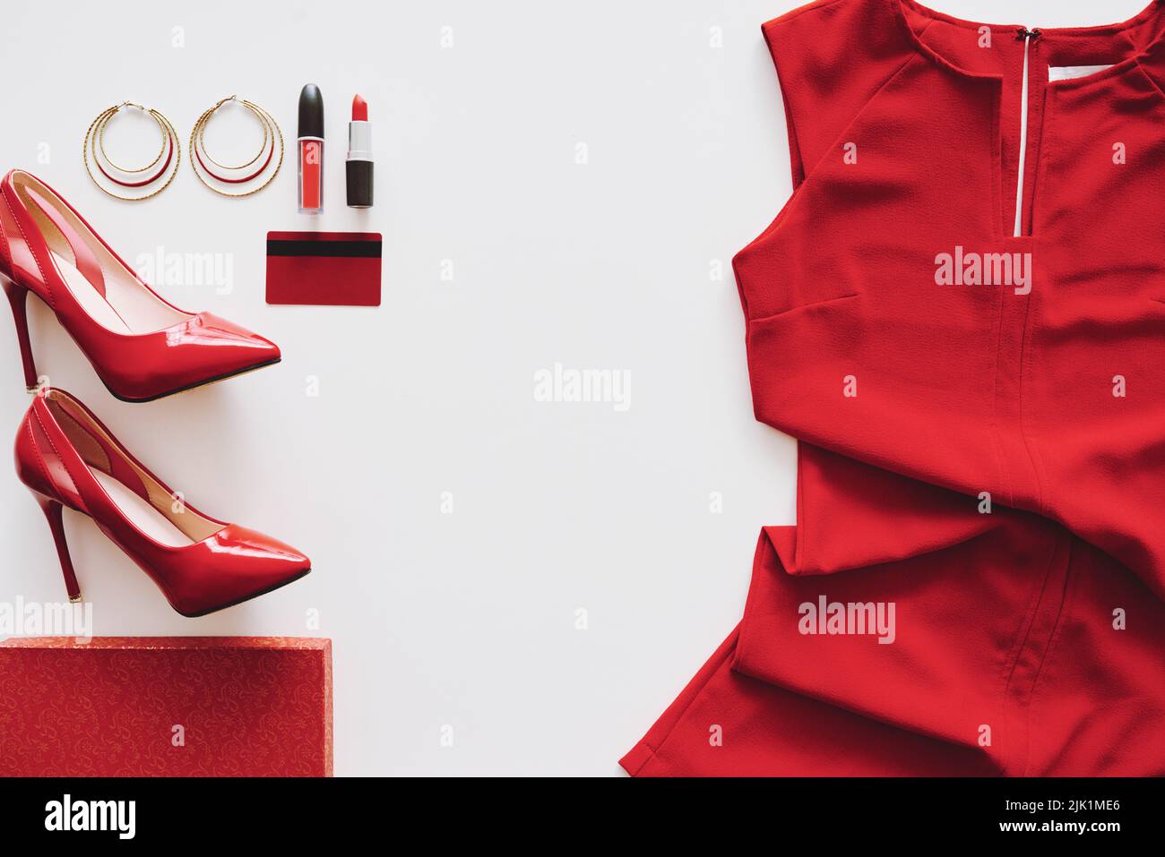 Rotes Kleid, Fersen und Kosmetik auf weißem Hintergrund Stockfoto
