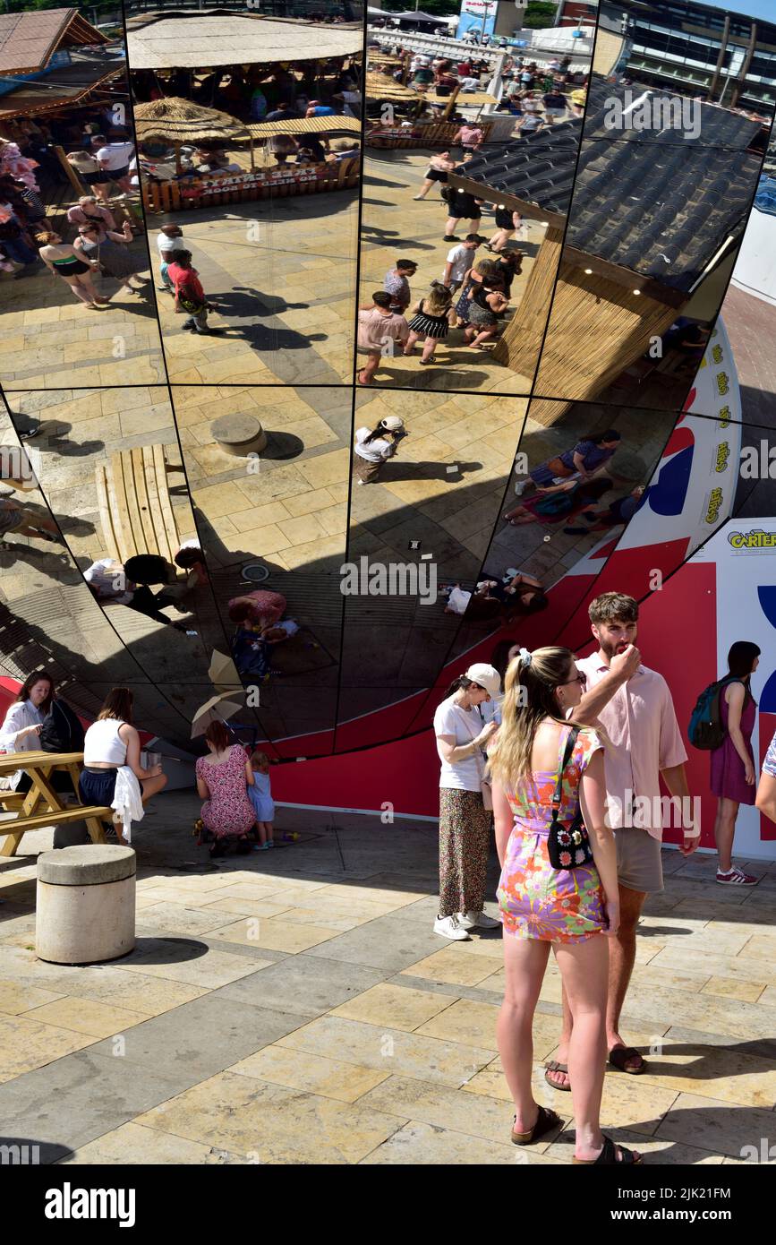 Menschen in Bristol Millennium Square mit Reflexionen in Spiegel Globus Stockfoto