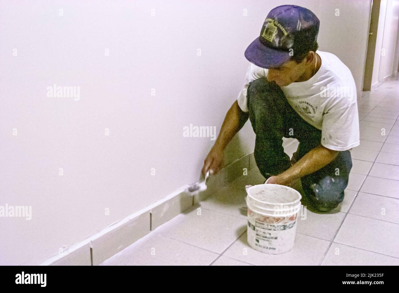 Miami Beach Florida, Hispanic Mann Installierer Installation neuer Fliesen innerhalb der Innenkondominium Eigentumswohnung Wohn-Apartment Gebäude Flur Arbeiter arbeiten Stockfoto