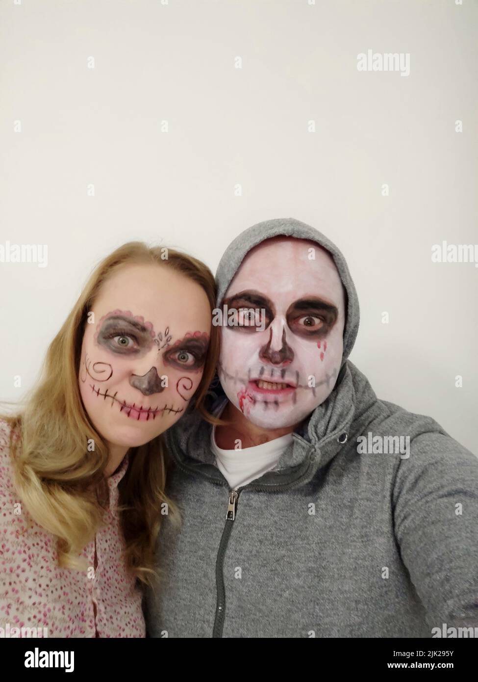 Junge Menschen mit einem bemalten Schädel auf ihrem Gesicht auf weißem Hintergrund. Feier des Tages der Toten Stockfoto