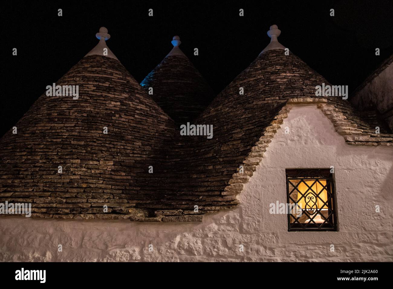 Malerische verlassene Straße im Trulli-Viertel von Alberobello bei Nacht, Italien Stockfoto