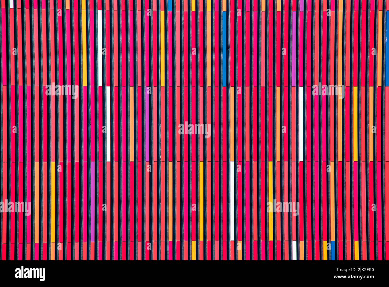 Geometrischer Hintergrund in bunten, mehrfarbigen Streifen in Rottönen. Abstrakter Hintergrund oder Textur. Stockfoto