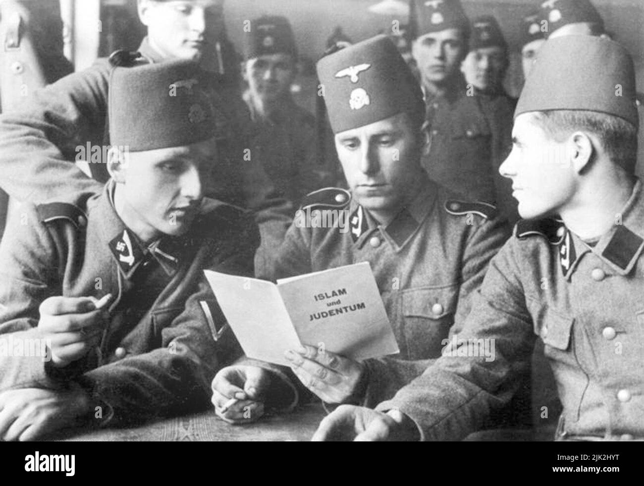 Soldaten der SS-Division 13. der SS Handschar (1. Kroatisch) mit einer Broschüre über 'Islam und Judentum', 1943 Stockfoto