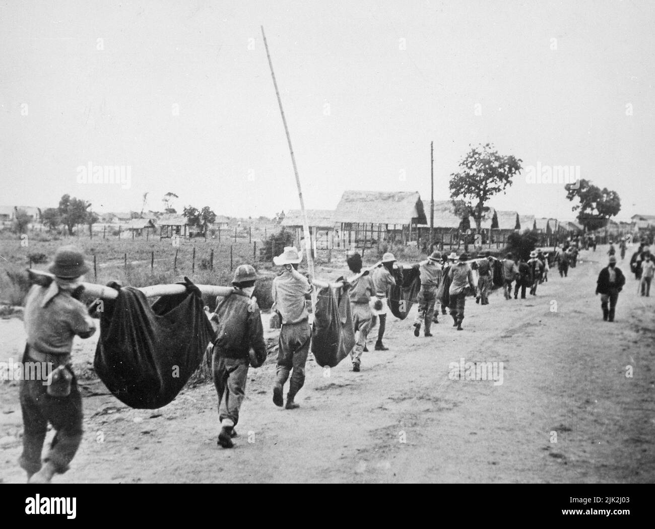 Foto von amerikanischen Gefangenen, die improvisierte Würfe benutzten, um Kameraden auf dem Todesmarsch von Bataan zu tragen. Der Todesmarsch auf den Philippinen war um den 1942. Mai von Bataan nach Cabanatuan, dem Gefangenenlager Stockfoto