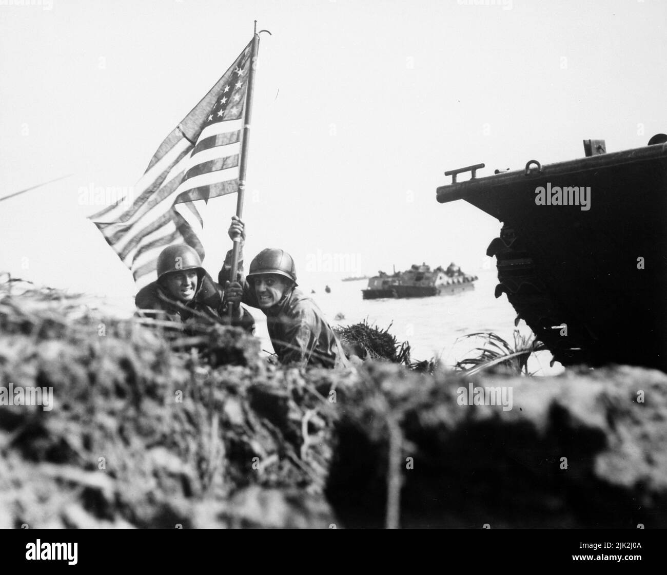 Zwei US-Offiziere setzen die erste amerikanische Flagge auf Guam, nachdem am 20. Juli 1944 Angriffstruppen der US-Marine und der Armee auf der Insel im Zentralpazifik gelandet sind. Stockfoto