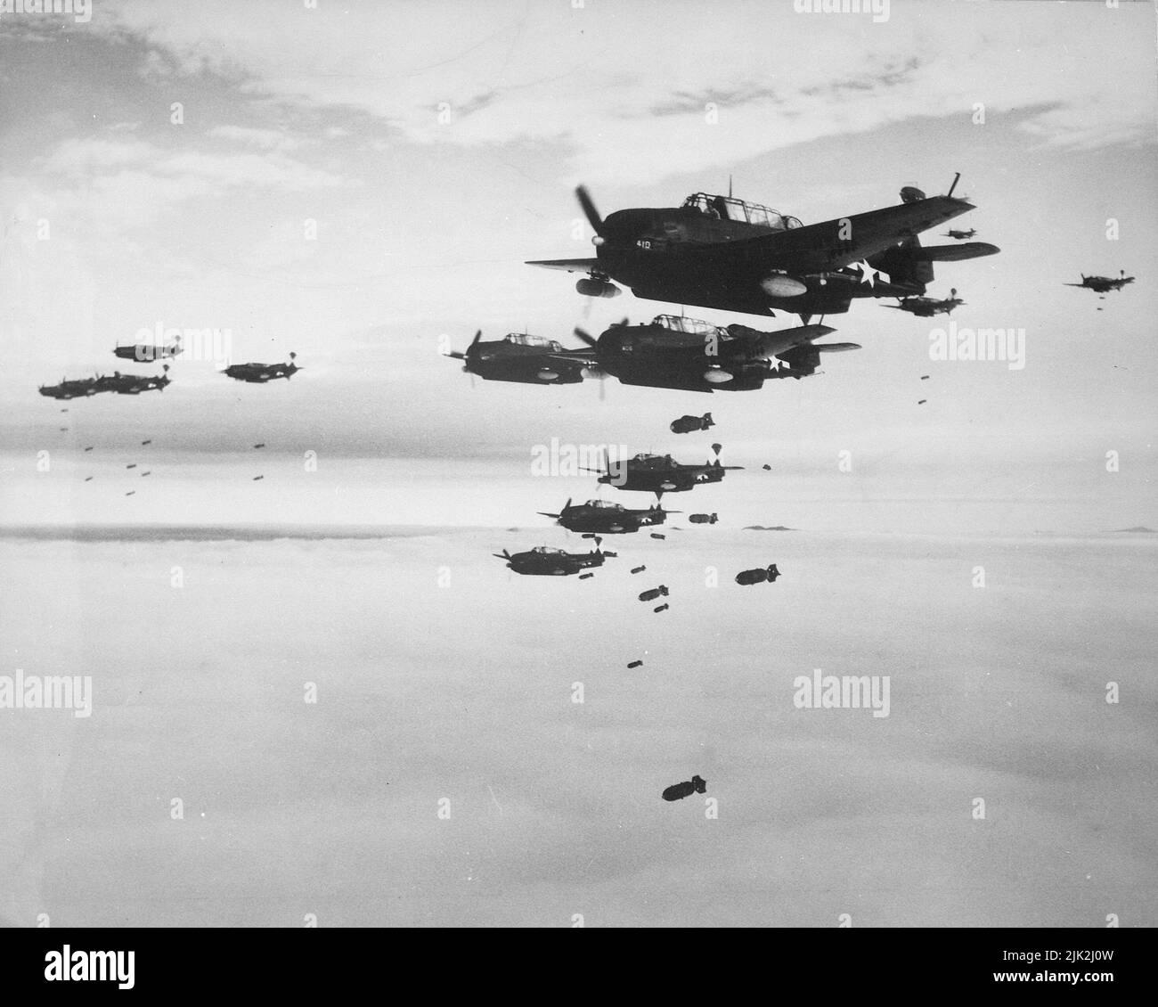 Grumman Avengers (aka TBMs) und Curtiss HELLDIVERS (aka SB2Cs), die Bomben auf Hokadate, Japan, abwarfen, Juli 1945 während des Zweiten Weltkriegs Stockfoto
