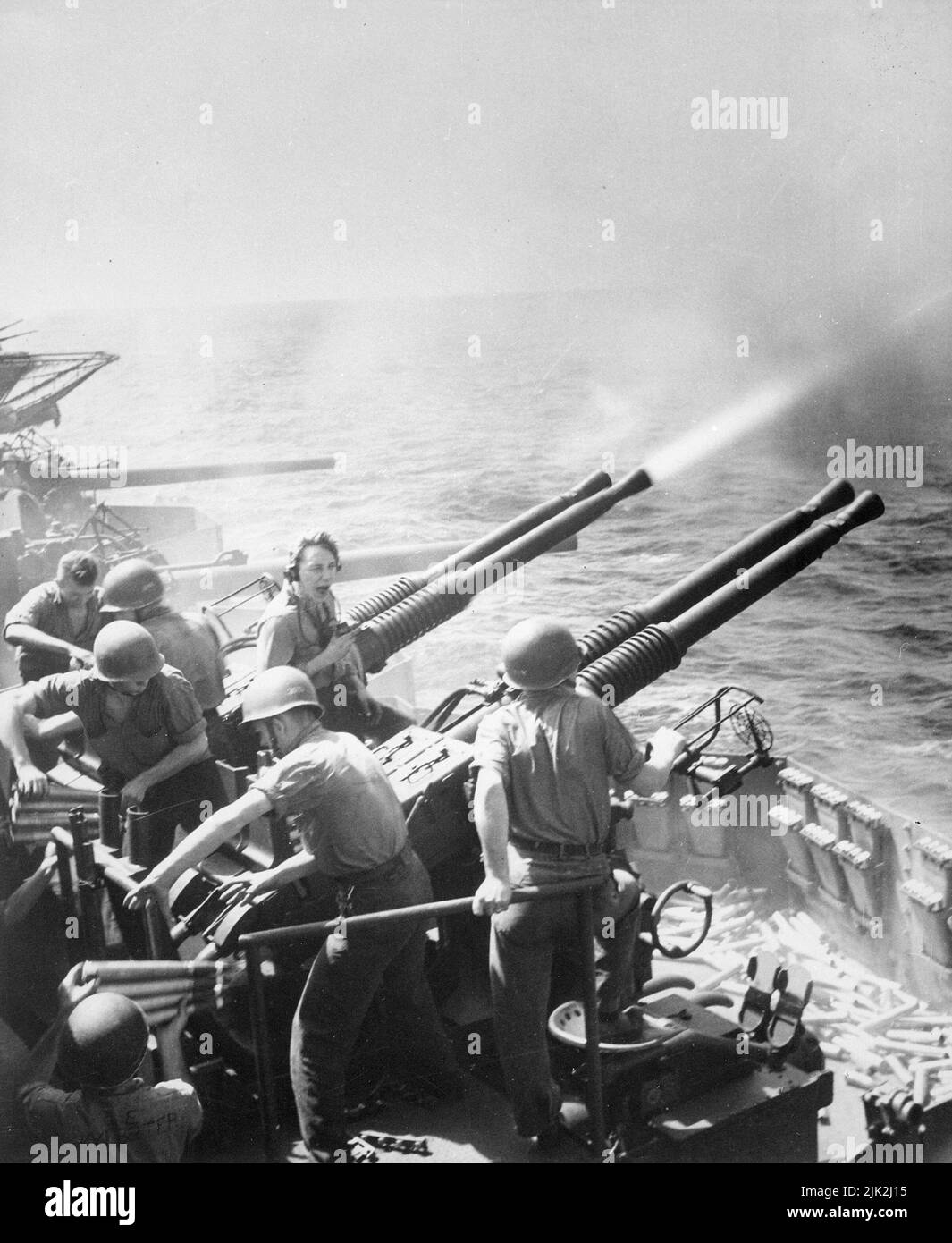 RAID der Task Force 58 auf Japan. Am 16. Februar 1945 feuerten 40mm Geschütze an Bord der USS Hornet, als die Flugzeuge des Flugzeugträgers Tokio überfielen. Aufgewendete Granaten und gebrauchsfertige Munitionskunition rechts notieren. Stockfoto