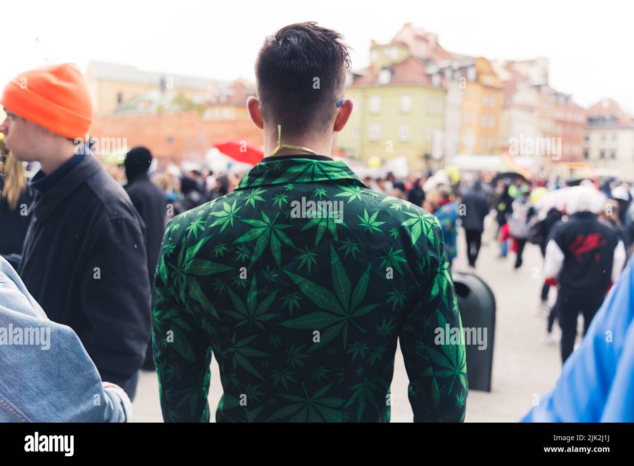 Außenaufnahme eines Rückens einer nicht erkennbaren kurzhaarigen Person, die einen dunkelgrünen Blazer mit Marihuanablättern trägt, die ein Muster bilden. Hochwertige Fotos Stockfoto