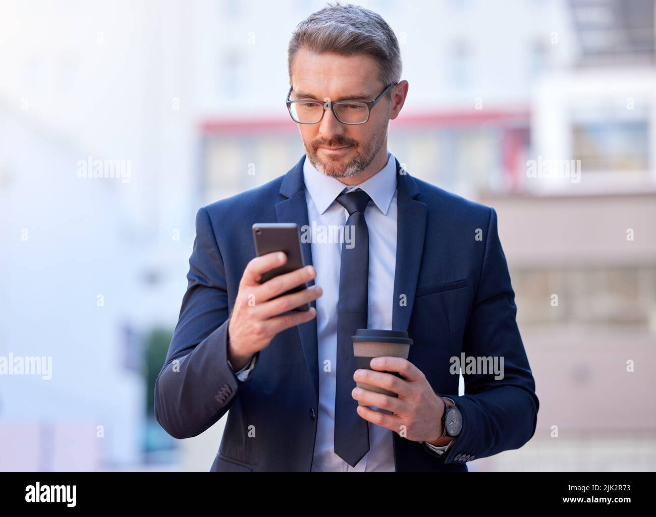 Hes immer schnell zu reagieren. Ein schöner reifer Geschäftsmann SMS, während draußen in der Stadt stehen. Stockfoto