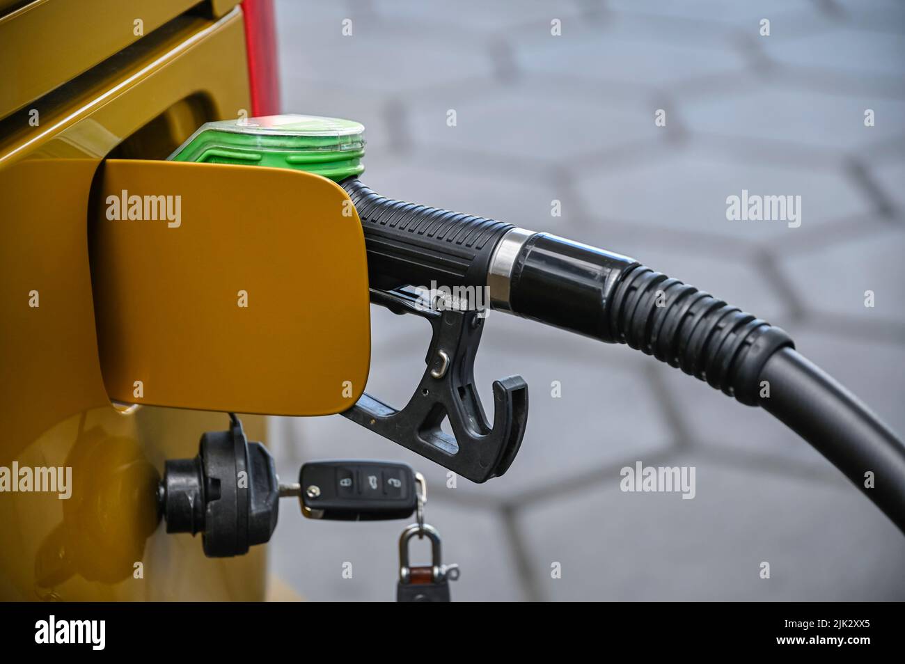Rosenheim, Deutschland. 29.. Juli 2022. An einer Tankstelle ist eine Pumpdüse im Einfüllstutzen eines Autos eingeklemmt. Wer im Ausland an der Tankstelle Geld sparen will, muss sich diesen Sommer von alten Ritualen lösen. Schließlich ist das Auffüllen auf der anderen Seite der Grenze nicht mehr so profitabel wie früher und ist in einigen Fällen zu einem Minusgeschäft geworden. Quelle: Uwe Lein/dpa/Alamy Live News Stockfoto
