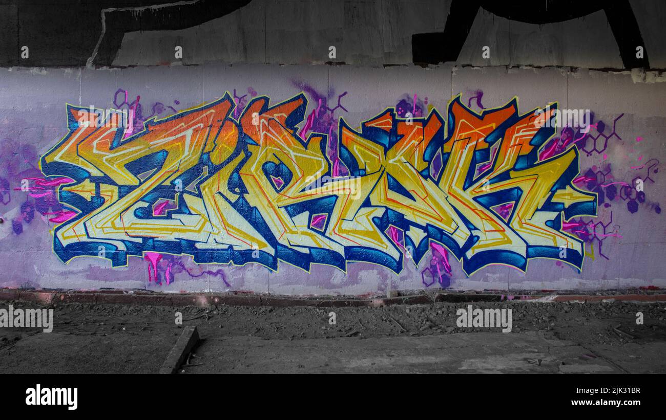 Farbenfrohe, abstrakte Graffiti-Buchstaben im Wildstil, die an einer Wand mit leuchtenden Farben und psychedelischen Formen gemalt oder gemalt wurden Stockfoto