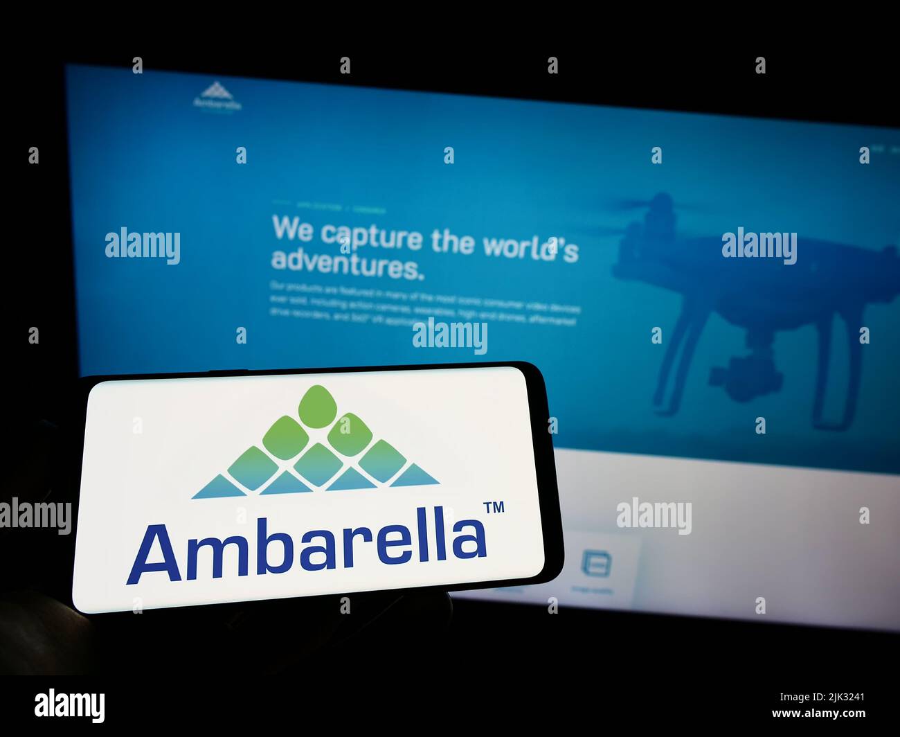 Person, die Mobiltelefon mit dem Logo des US-Halbleiterunternehmens Ambarella Inc. Auf dem Bildschirm vor der Business-Webseite hält. Konzentrieren Sie sich auf die Telefonanzeige. Stockfoto