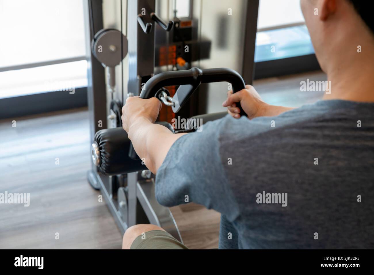Junger Mann Anfänger Training mit Hantel Flexing Muskeln in der Turnhalle, Sporttraining Konzept Stockfoto