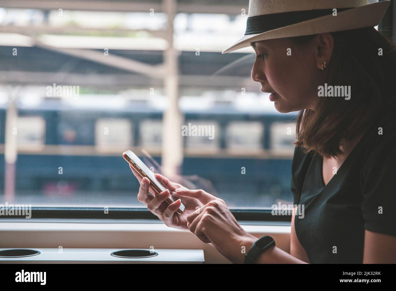 Schöne junge Frau Reisende mit Smartphone an einem Bahnhof, Transport und Reise Lifestyle-Konzept Stockfoto