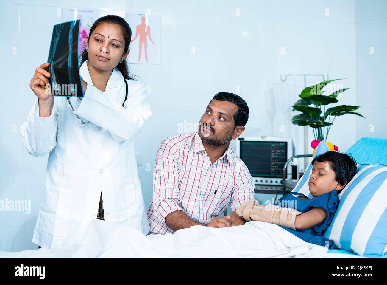 Arzt erklärt Kindern Röntgenbericht über gebrochene Hand an den Vater im Krankenhaus vor der Operation - Konzept des Kinderarztes, Kinderbetreuung und Verletzungen. Stockfoto Arzt erklärt Kindern Röntgenbericht über gebrochene Hand an den Vater im Krankenhaus vor der Operation - Konzept des Kinderarztes, Kinderbetreuung und Verletzungen. Stockfoto