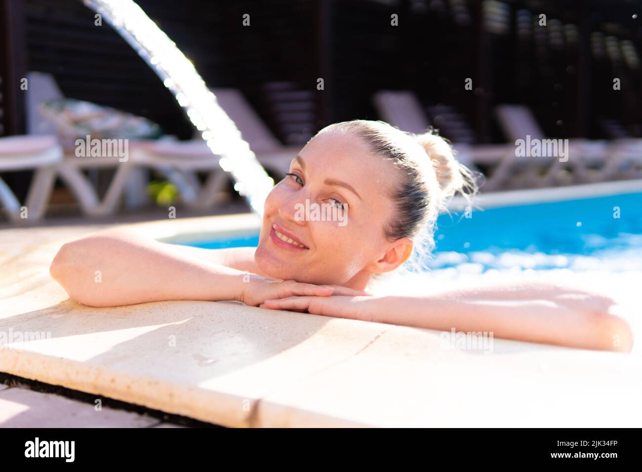 Lächelnd Pool Schwimmen Frau junge Wasserfall schönen Luxus im Freien entspannen, Konzept Urlaub genießen zum Ausruhen und planschen Vergnügen, geschlossenen Tropfen Stockfoto