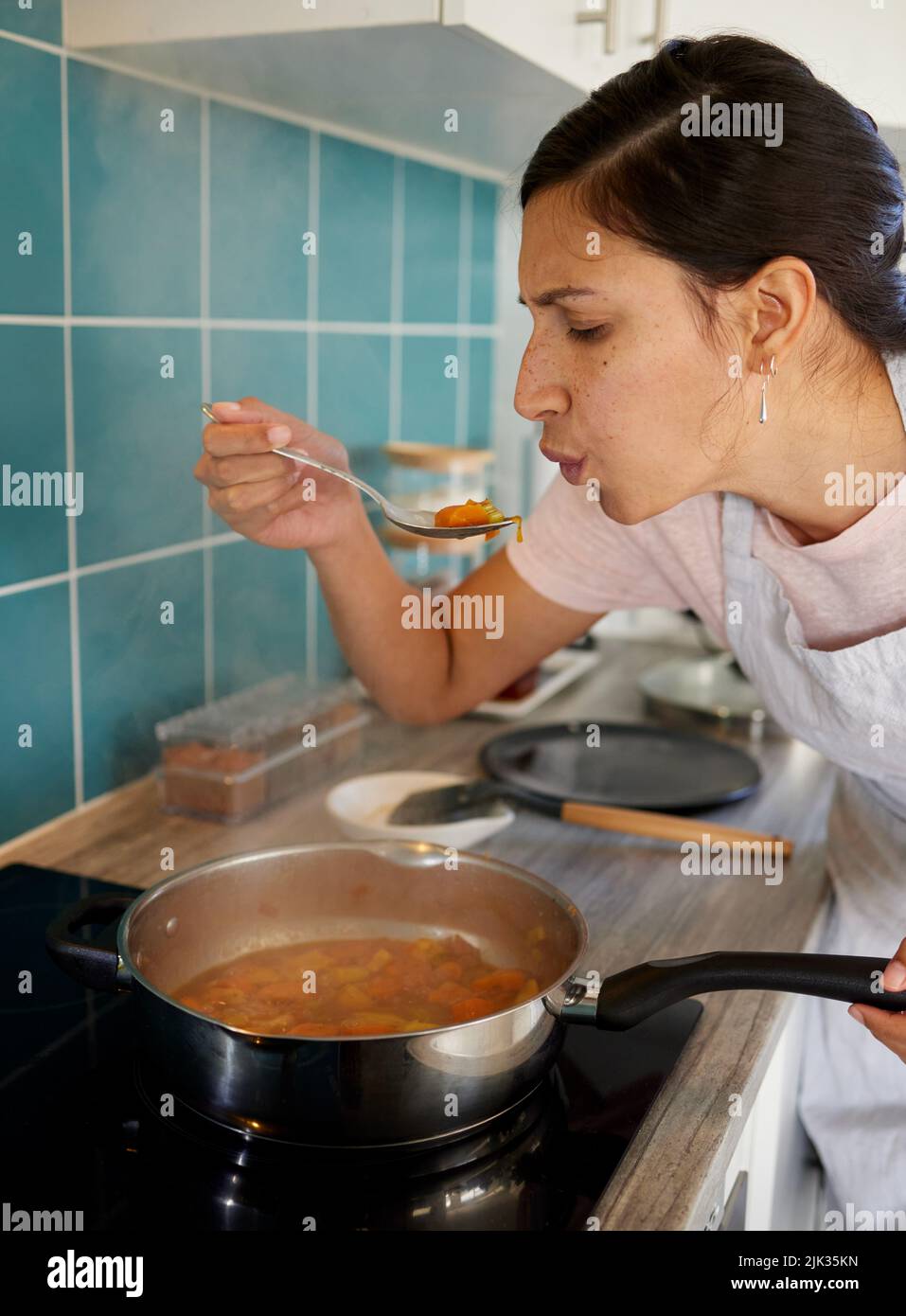 Immer schmecken, wie Sie gehen. Eine junge Frau schmeckte ihr Essen. Stockfoto