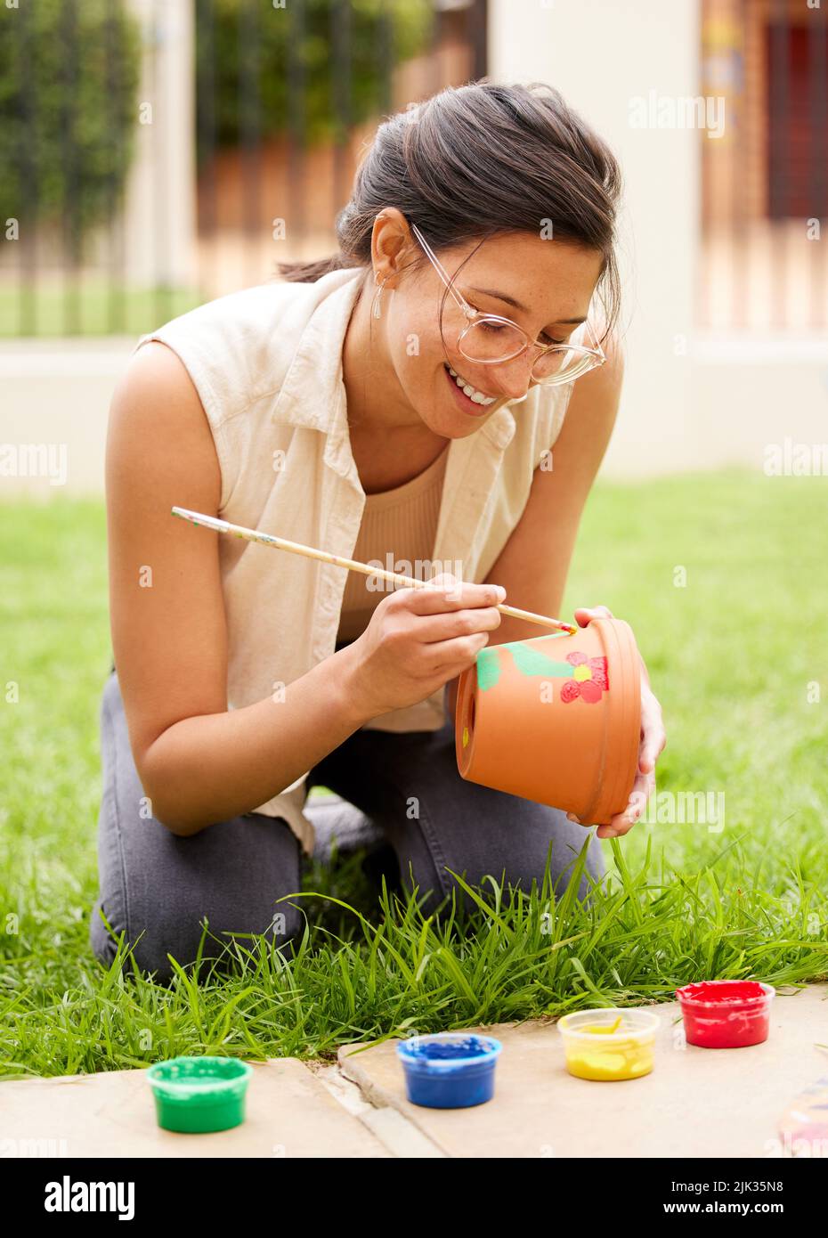 Phantasie ist der Anfang der Schöpfung. S junge Frau malen einen Topf im Garten zu Hause. Stockfoto
