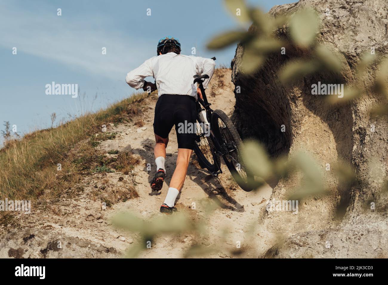 Professioneller Radsportler mit seinem Fahrrad auf dem Hügel, Erwachsener Sportler auf dem Trail Stockfoto