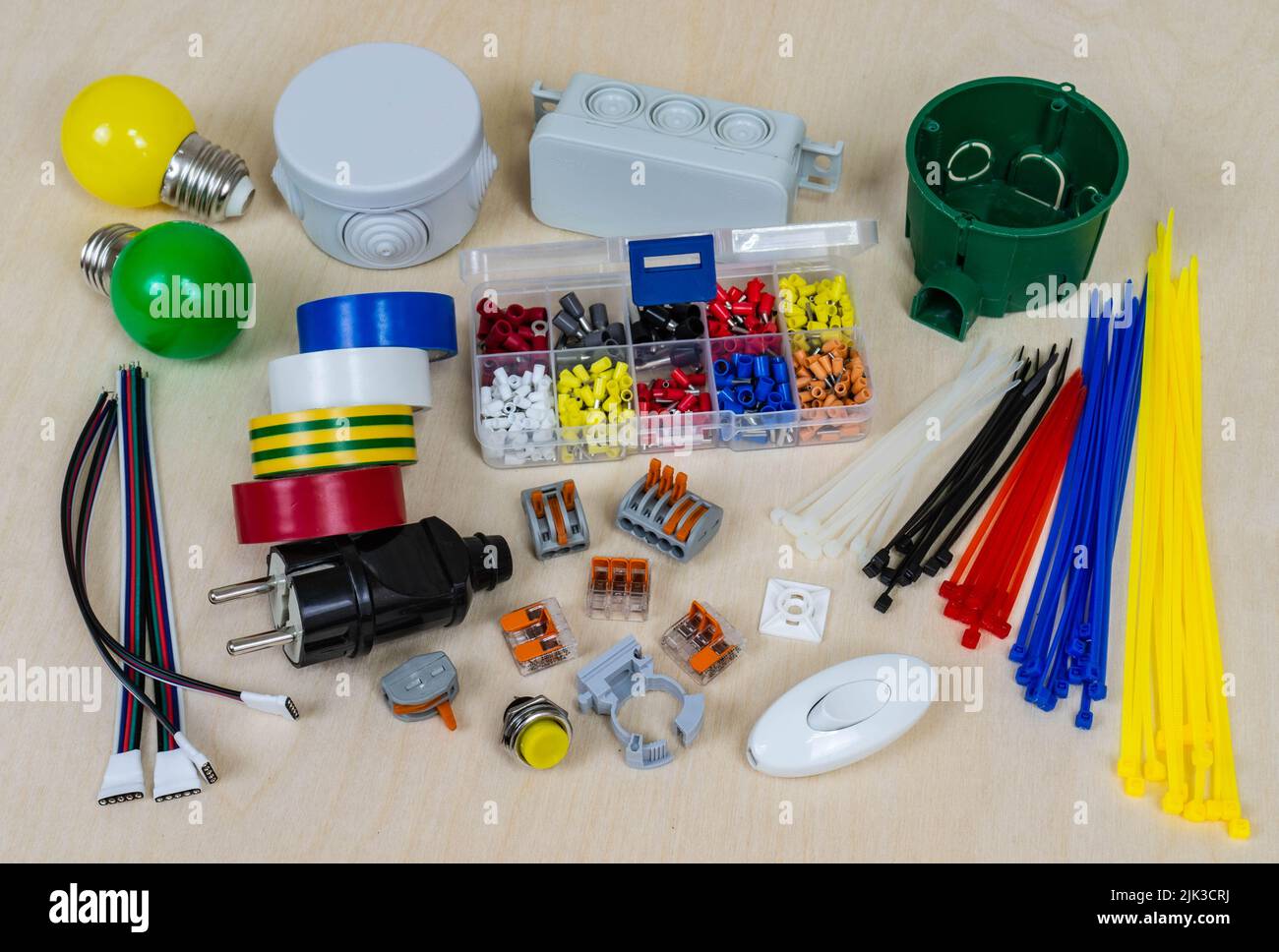 Mehrfarbige elektrische Bauteile und Teile auf einem Sperrholzhintergrund. Stockfoto