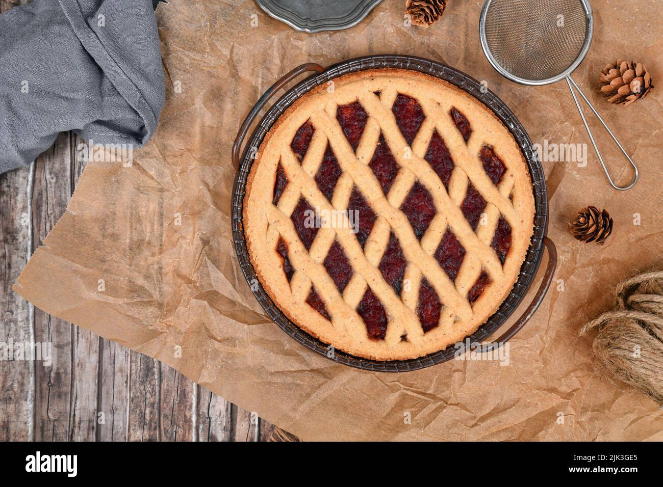 Draufsicht auf hausgemachten Kuchen namens 'Linzer Torte', ein traditionelles österreichisches Shortcake-Gebäck mit Obstkonserven und gemahlenen Nüssen mit Gitterdessig Stockfoto