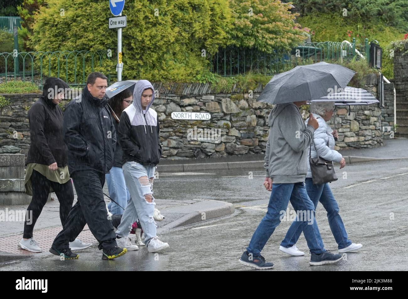 Ambleside, Cumbria, Großbritannien. Juli 30. 2022. Besucher von Ambleside, Cumbria, werden unter Regenschirmen geschützt, während schwere Regengüsse die Region treffen. Trotz des Regens, der für Gärtner eine willkommene Erleichterung darstellt, hangen die Temperaturen an dem, was als „trockenster Juli seit 1911“ bezeichnet wurde, immer noch um die 18 Grad celsius. Bild von: Michael Scott / Alamy Live News Stockfoto