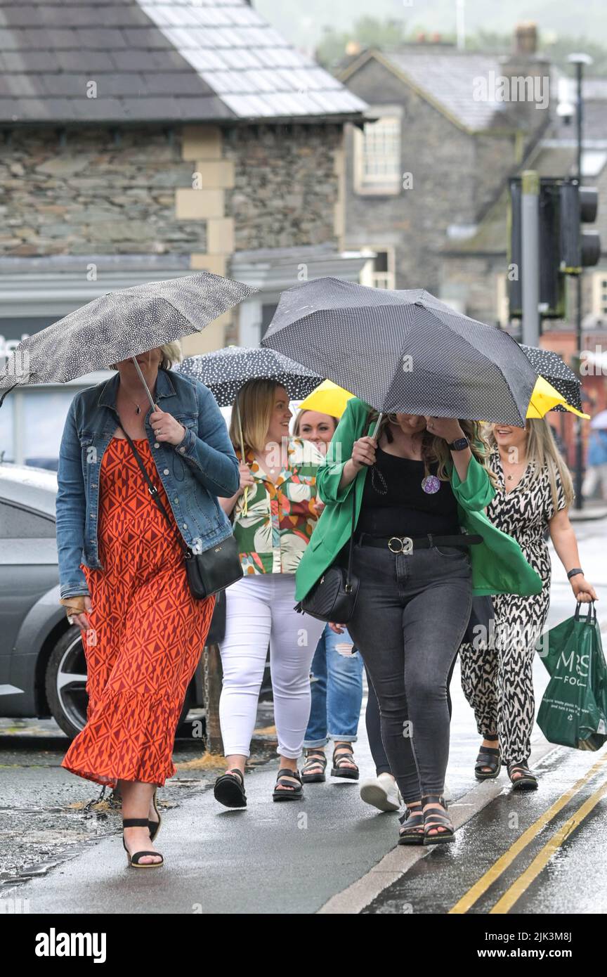 Ambleside, Cumbria, Großbritannien. Juli 30. 2022. Besucher von Ambleside, Cumbria, werden unter Regenschirmen geschützt, während schwere Regengüsse die Region treffen. Trotz des Regens, der für Gärtner eine willkommene Erleichterung darstellt, hangen die Temperaturen an dem, was als „trockenster Juli seit 1911“ bezeichnet wurde, immer noch um die 18 Grad celsius. Bild von: Michael Scott / Alamy Live News Stockfoto