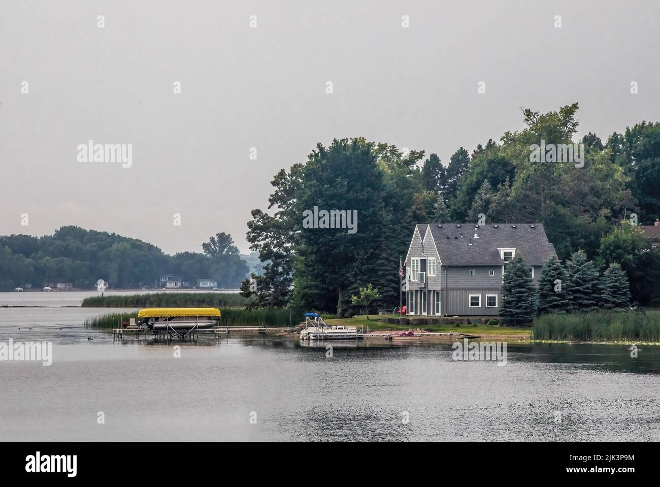 Zuhause mit einem Dock und Booten auf South Center Lake in Lindstrom, Minnesota USA an einem bewölkten bewölkten bewölkten Tag. Stockfoto