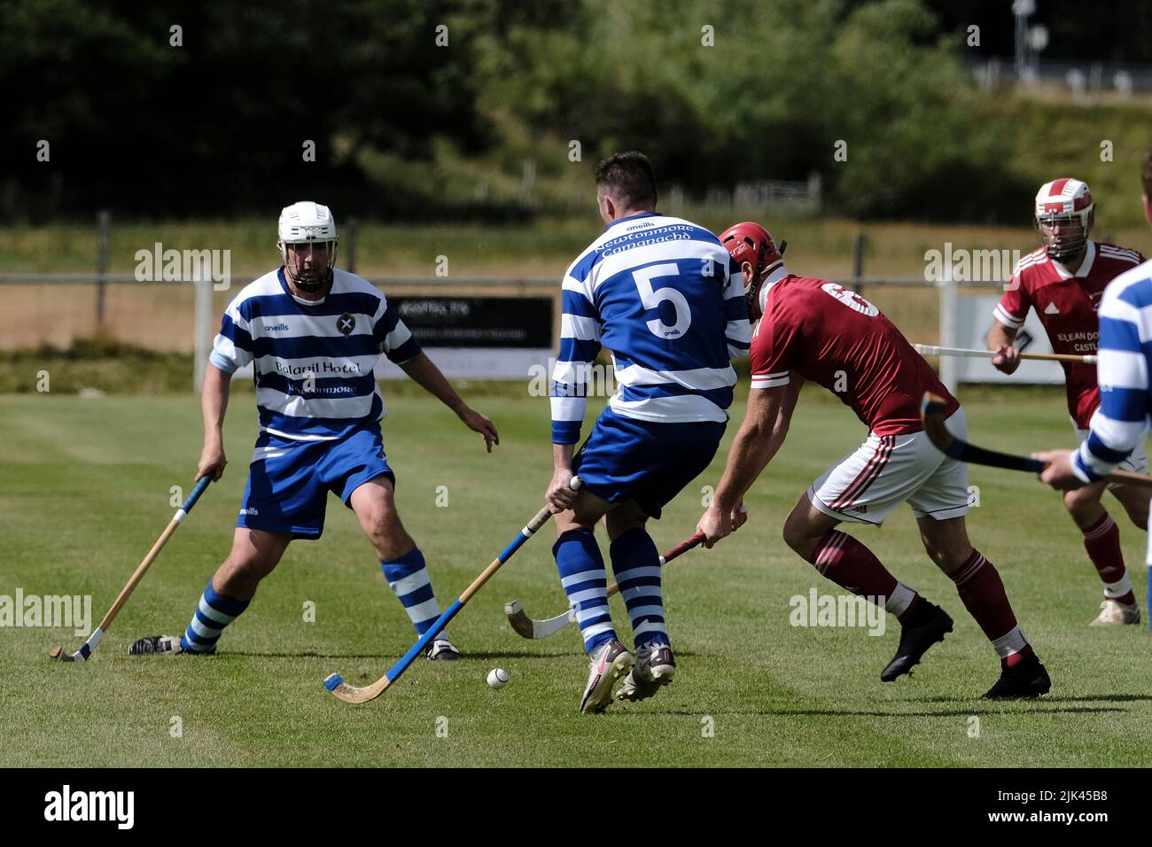 Newtonmore, Großbritannien. 30 Juli 2022. Newtonmore Camanachd Club First Team spielt Kinlochshiel auf der Eilan in der Mowi Premiership. Kingussie (in weiß und blau) gegen Kinlochshiel. Endergebnis 2-2. MOWI Premiership Ligaspiel. Shinty, oder „Camanachd“ in Schottland, ist ein Spiel, das nur in den Highlands zwischen Teams gespielt wird, die Dörfer und Städte repräsentieren. Das Spiel ist älter als die aufgezeichnete Geschichte Schottlands und wird auf einem Rasen mit einem kleinen Ball und Stöcken (genannt Caman) gespielt. . Kredit: Rob Gray/Alamy Live Nachrichten Stockfoto