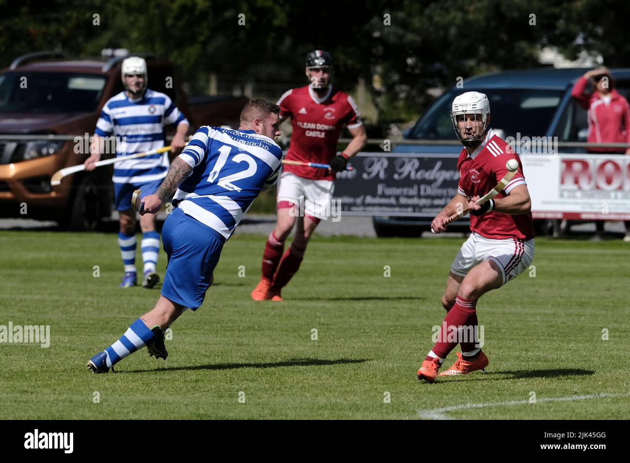 Newtonmore, Großbritannien. 30 Juli 2022. ::: Newtonmore Camanachd Club First Team spielt Kinlochshiel auf der Eilan in der Mowi Premiership. Kingussie (in weiß und blau) gegen Kinlochshiel. Endergebnis 2-2. MOWI Premiership Ligaspiel. Shinty, oder „Camanachd“ in Schottland, ist ein Spiel, das nur in den Highlands zwischen Teams gespielt wird, die Dörfer und Städte repräsentieren. Das Spiel ist älter als die aufgezeichnete Geschichte Schottlands und wird auf einem Rasen mit einem kleinen Ball und Stöcken (genannt Caman) gespielt. . Kredit: Rob Gray/Alamy Live Nachrichten Stockfoto