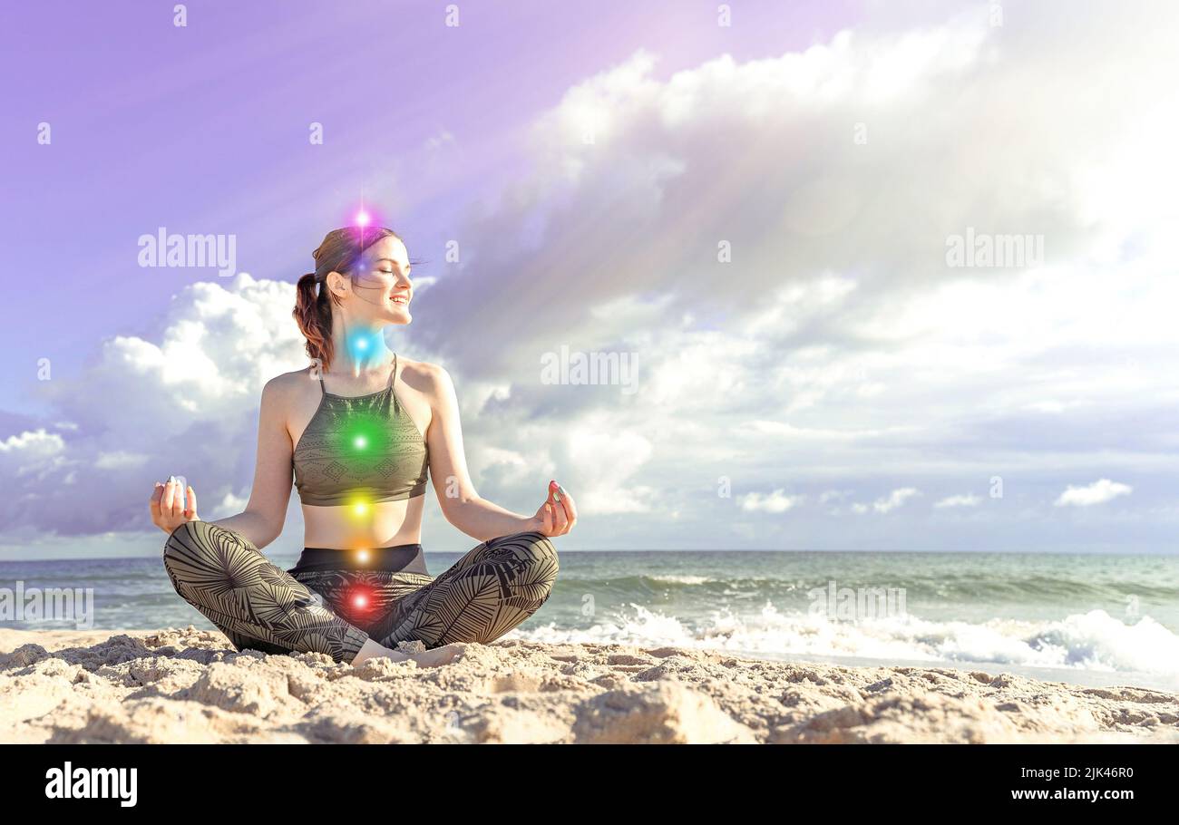 7 Chakren. Glückliche Frau meditiert an der Küste. Mädchen in Lotusposition Stockfoto