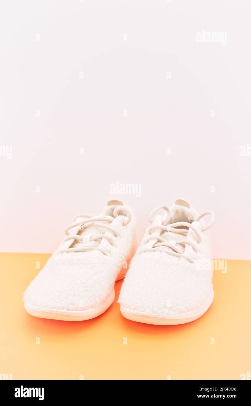 Weiße sportliche Sneakerschuhe aus Wolle auf einem Schreibtisch mit Platz für Text Stockfoto