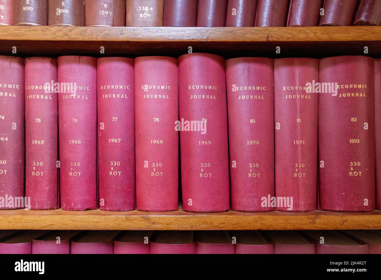 Eine Reihe von alten 1960s Wirtschaftszeitschriften, die in Rot auf dem Regal in der liverpool-Bibliothek gebunden sind Stockfoto