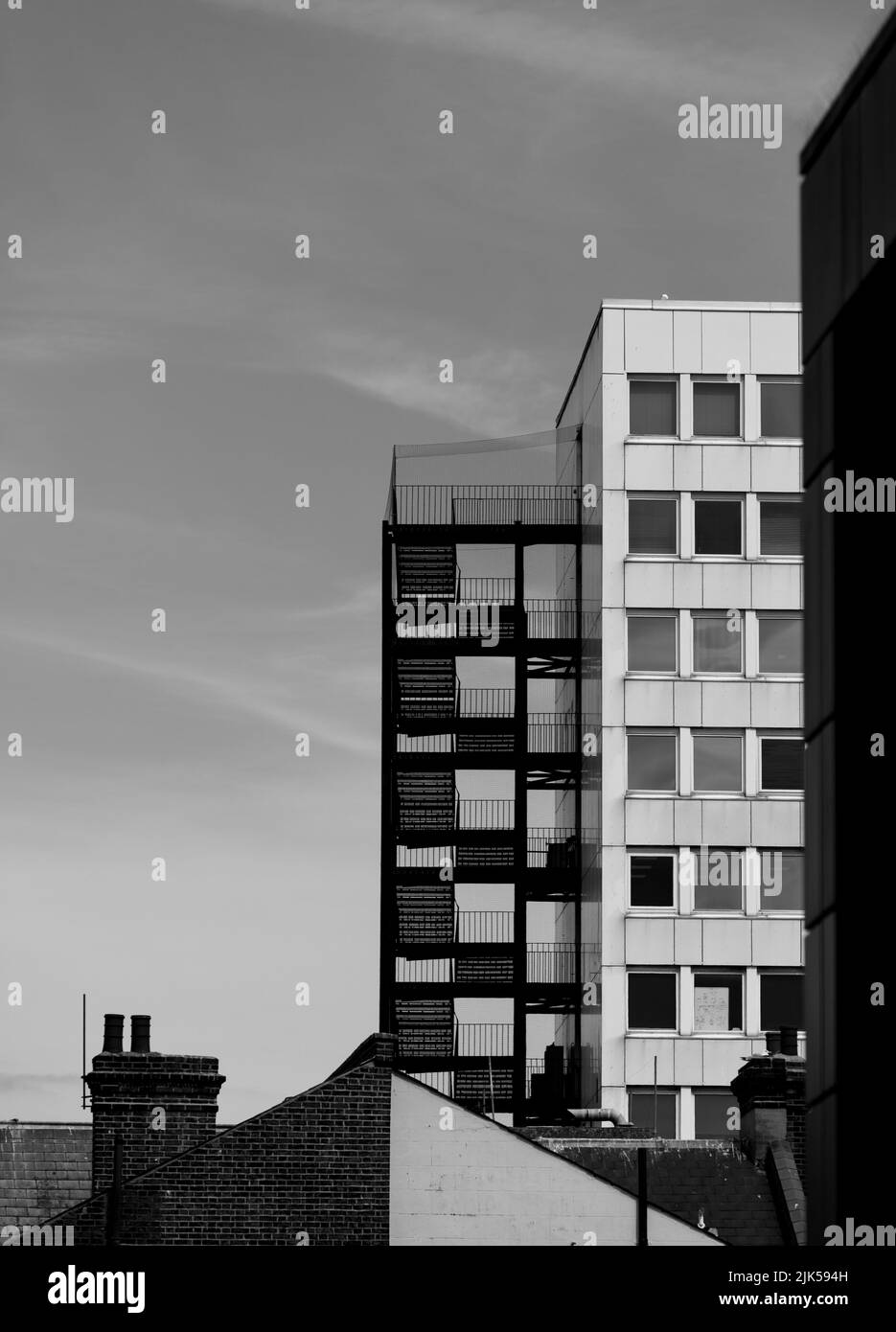 Ein Bürogebäude mit Außentreppe in Schwarz und Weiß vor klarem Himmel Stockfoto