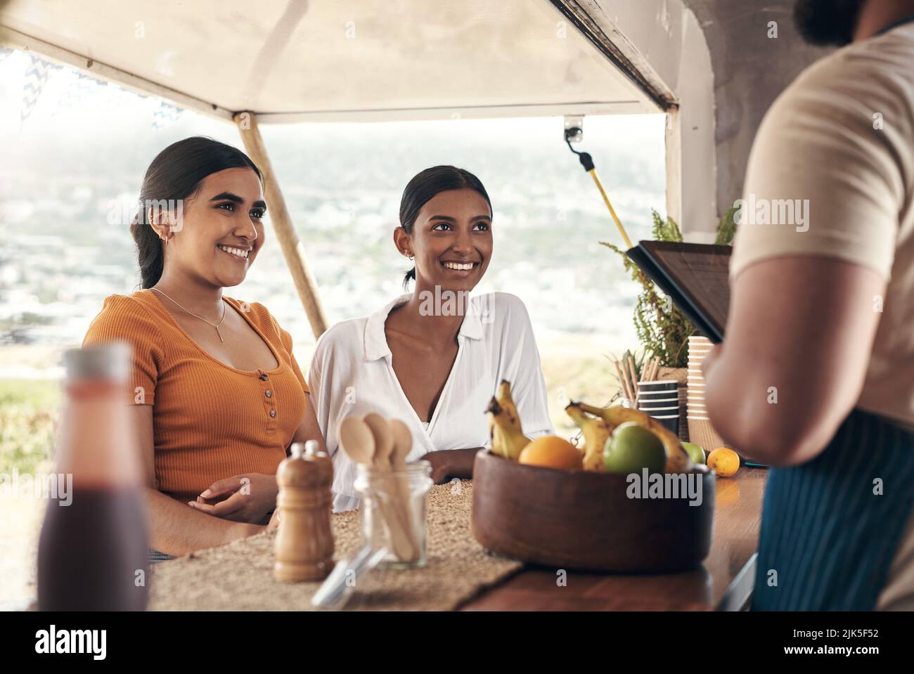 Es sollte in kürzester Zeit fertig sein. Zwei Freunde bestellen Lebensmittel von einem Food Truck. Stockfoto