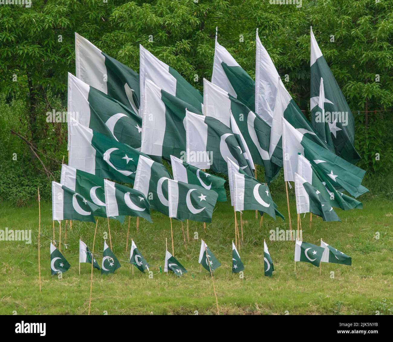 Die Nationalflagge Pakistans wird hier in Islamabad auf der Straßenseite angezeigt, um den Tag der pakistanischen Unabhängigkeit zu feiern. Stockfoto